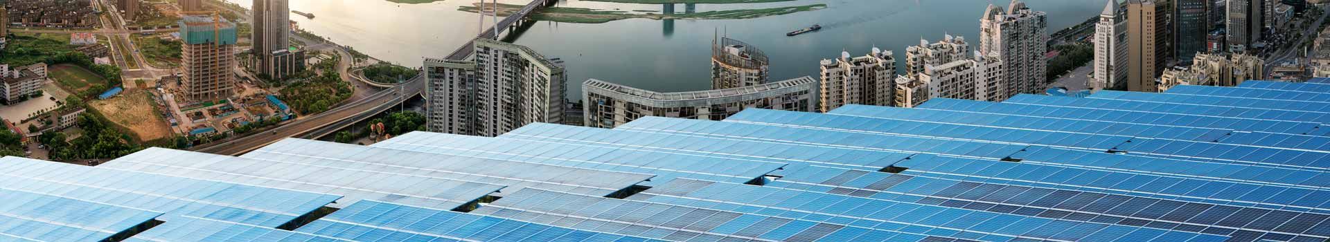 Große Photovoltaikfläche vor einer städtischen Hochhauskulisse