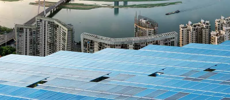 Große Photovoltaikfläche vor einer städtischen Hochhauskulisse