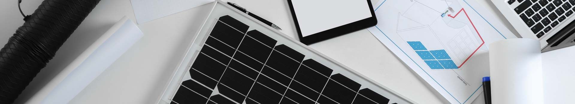 Solarmodul und Planungsunterlagen auf einem Schreibtisch