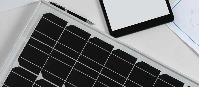 Solarmodul und Planungsunterlagen auf einem Schreibtisch