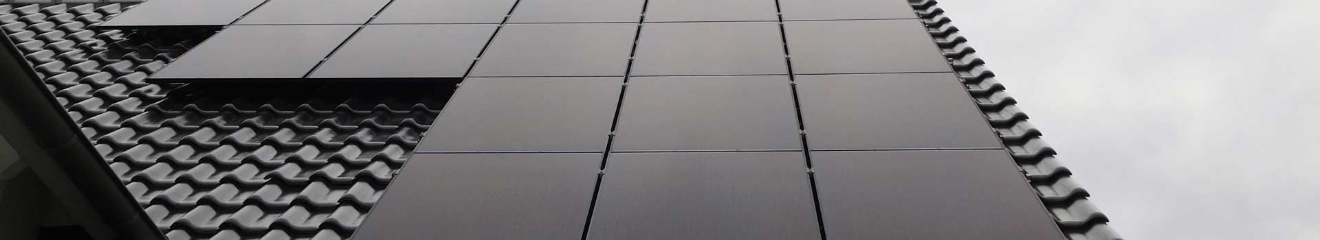 Schwarze Solarmodule auf einem dunklen Ziegeldach