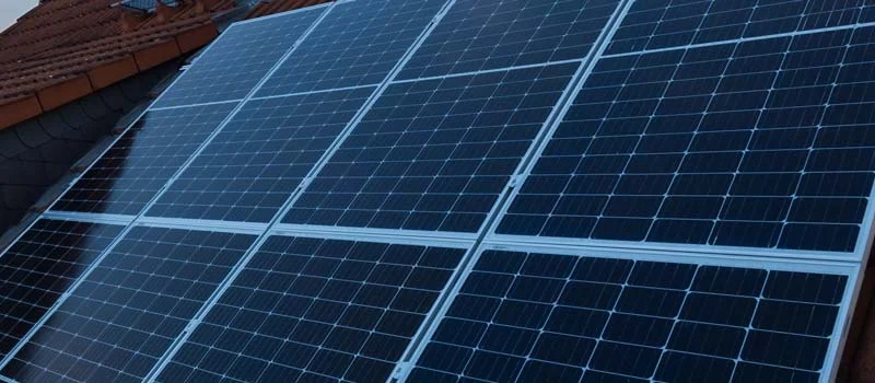 Solarmodule auf einem geneigten Dach neben einem Baugerüst