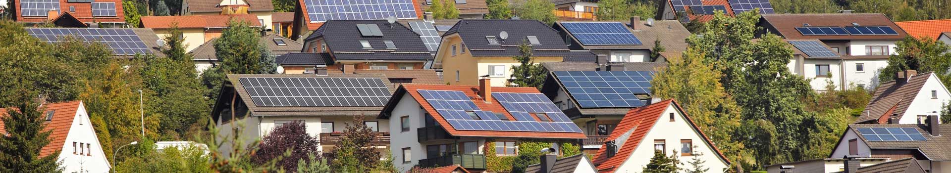 Wohnhäuser mit Photovoltaik-Anlagen auf mehreren Dächern