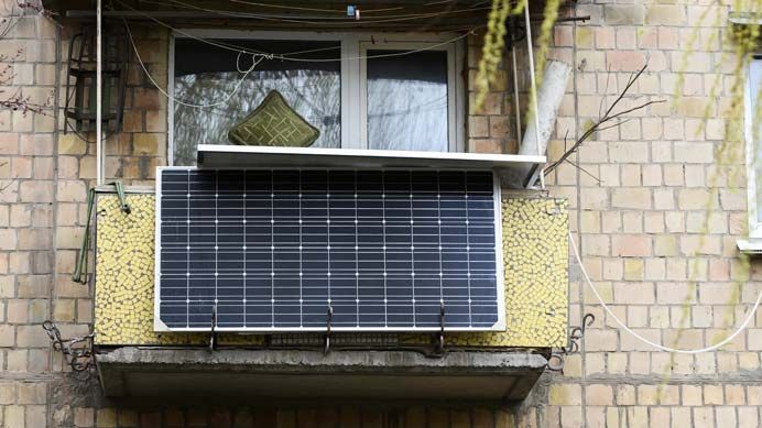 Ein Solarmodul ist vor einem Balkongeländer angebracht