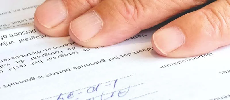Symbolbild: Hand auf einem ausgefüllten Formular