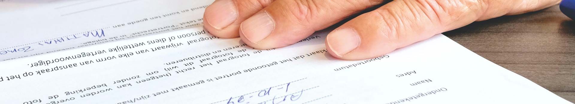 Symbolbild: Hand auf einem ausgefüllten Formular