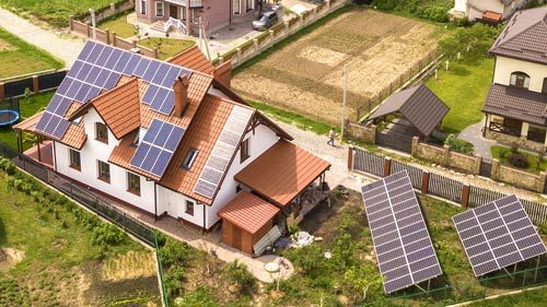 Haus mit PV-Modulen auf dem Dach und zusätzlichen Modulflächen im Garten