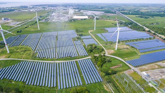Luftaufnahme eines Solarparks mit benachbarten Windenergieanlagen