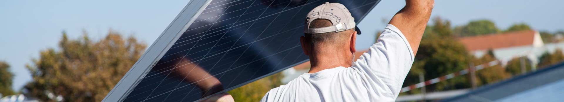 Solarinstallateur trägt ein Photovoltaikmodul