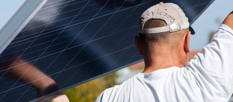Solarinstallateur trägt ein Photovoltaikmodul
