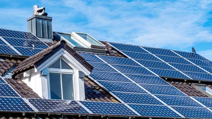 Photovoltaikmodule auf einem Dach mit Gaube und Schornstein