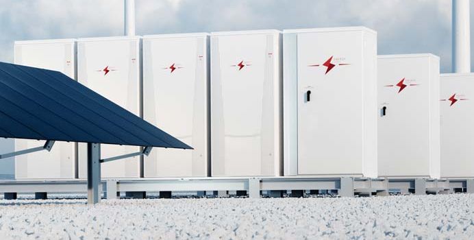 Symbolbild mit mehreren Speichergehäusen neben Solarmodulen