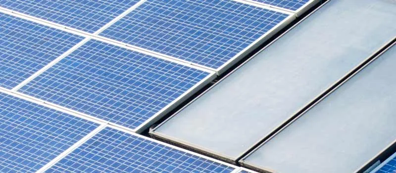 Photovoltaikmodule und Solarthermiekollektoren auf einem Dach; kein Herkunftsnachweis der Module