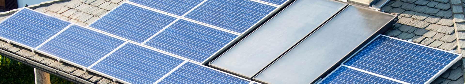 Photovoltaikmodule und Solarthermiekollektoren auf einem Dach; kein Herkunftsnachweis der Module