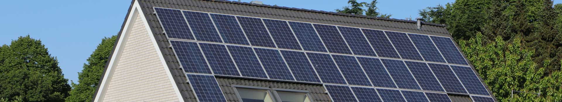 Solarmodule auf einem Hausdach mit Dachfenstern