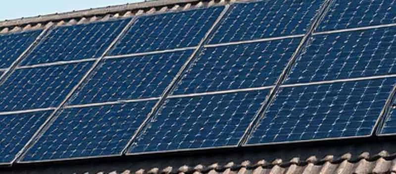 Solarmodule auf einem geneigten Ziegeldach neben einem Schornstein