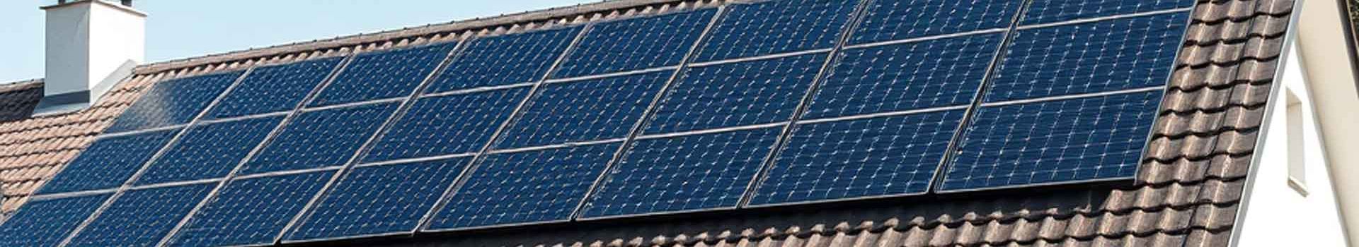 Solarmodule auf einem geneigten Ziegeldach neben einem Schornstein