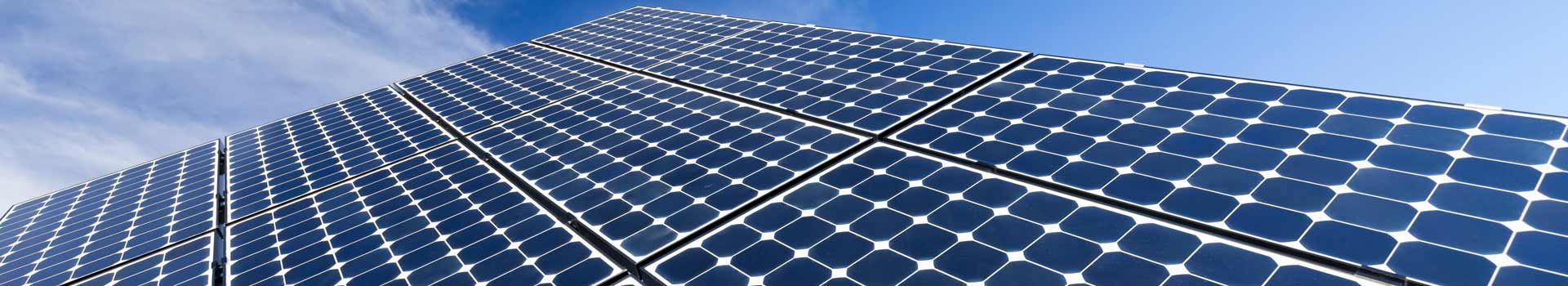 Nahaufnahme mehrerer Solarmodule vor blauem Himmel
