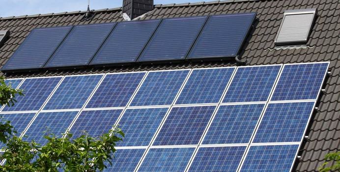 Photovoltaikmodule und Solarthermiekollektoren auf einem Hausdach