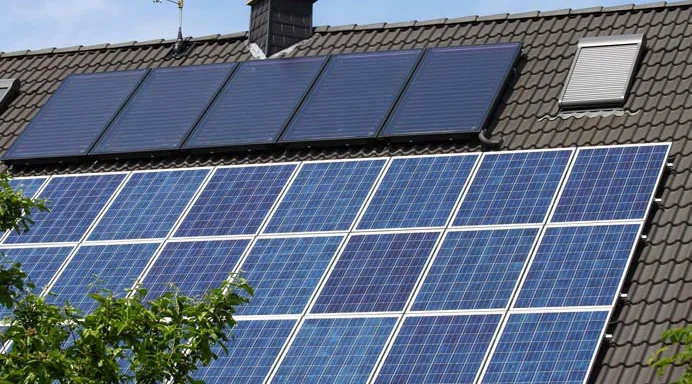 Photovoltaikmodule und Solarthermiekollektoren auf einem Hausdach